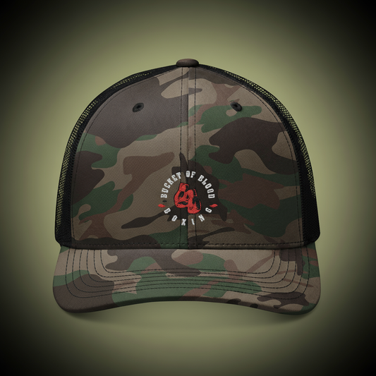Embroidered “Bucket of Blood” camo hat, rugged trucker hat with six-panel front, breathable mesh back, and adjustable snap closure